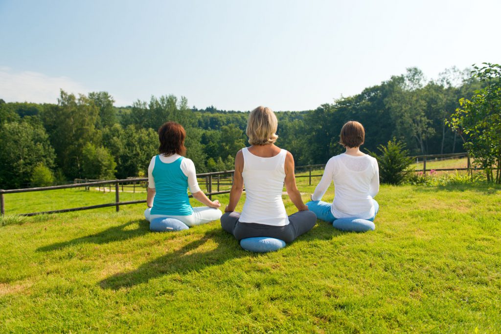 Drei Frauen entspannen beim Yoga im Hotel Heinz