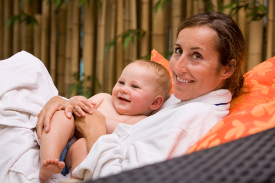 Mutter entspannt mit Baby im Sonnenpark in Willingen